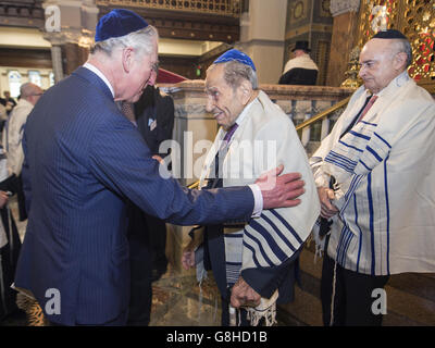 The Prince of Wales meets Reginald Gourgey (centre), a member of the congregation who turns 101 years old on Saturday, as he marks the 175th anniversary of the West London Synagogue by attending a special 'siyyum' service followed by a reception for members of the congregation in London. Stock Photo