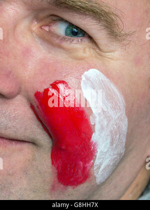 Closeup of young Polish supporter face painted with national flag colors Stock Photo