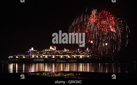 Fireworks are let off as Cunard's Queen Mary 2, one of the Three Queens liners, makes her way down Southampton water into the River Solent on her first world voyage of 2016. Stock Photo