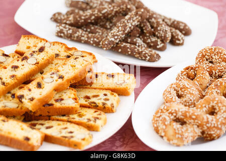 Different crackers in plates on pink cloth background. Stock Photo