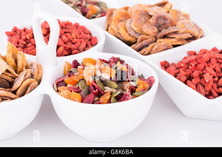 Dried fruits, berries and seeds in bowls closeup picture. Stock Photo