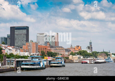 Skyline of Hamburg and ferry landing bridges from the River Elbe in Germany Stock Photo
