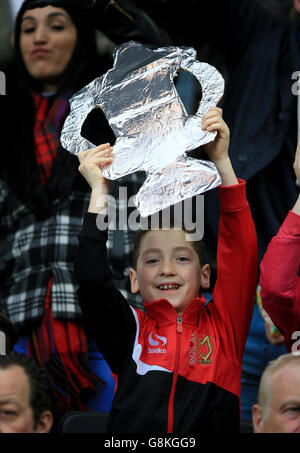 A young Milton Keynes Dons fan holds up a cardboard FA Cup in the stands during the Emirates FA Cup, fourth round match at Stadium:MK, Milton Keynes. Stock Photo