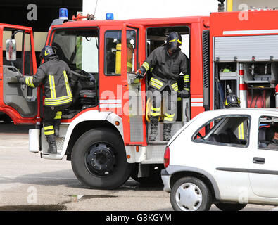 two Firefighters descend quickly from firetrucks after the road accident Stock Photo