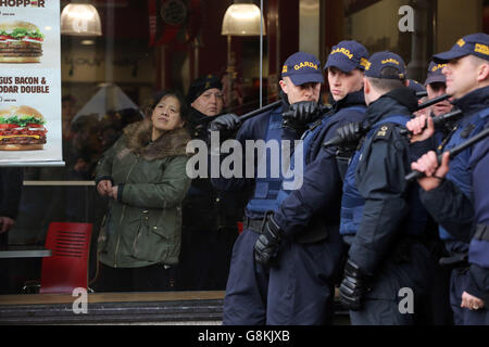 Patrons look on from inside a Burger King restaurant in Dublin city centre as members of the Garda Public Order Unit confront anti-racism protesters during a counter demonstration against the launch of an Irish branch of Pegida, the far-right movement from Germany. Stock Photo