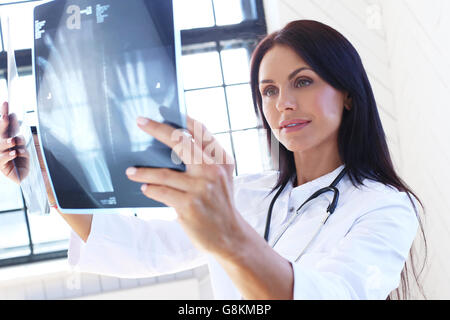 Young brunette woman doctor nurse in blue medical gown holds out her ...
