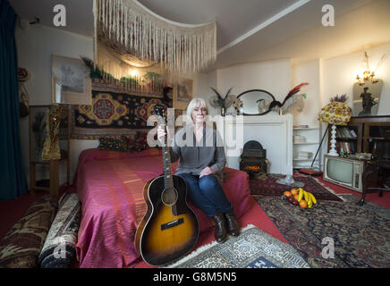 Jimi Hendrix's former girlfriend Kathy Etchingham poses on the musician's bed during the press preview of the new heritage site celebrating Jimi Hendrix at the flat he lived in between 1968 and 1969 on Brook Street, London. Stock Photo