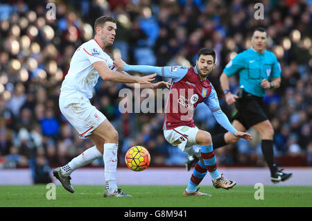 Liverpool's Jordan Henderson (left) and Aston Villa's Carles Gil battle for the ball during the Barclays Premier League match at Villa Park, Birmingham. Stock Photo