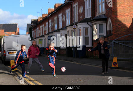 Young Nottingham Forest fans playing football in the street prior to the Emirates FA Cup, fourth round match at the City Ground, Nottingham. Stock Photo