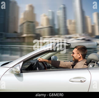 happy man driving cabriolet car on city Stock Photo