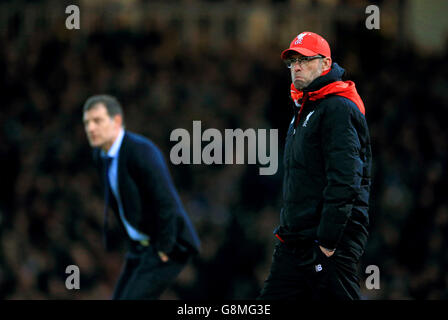 Liverpool manager Jurgen Klopp alongside West Ham United manager Slaven Bilic on the touchline during the Emirates FA Cup, fourth round replay match at Upton Park, London. Stock Photo