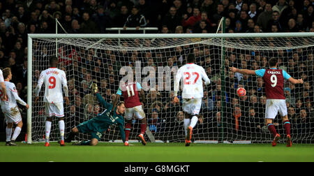 Liverpool goalkeeper Simon Mignolet dives in vain as West Ham United score their second goal the Emirates FA Cup, fourth round replay match at Upton Park, London. Stock Photo