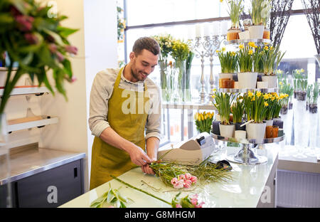 smiling florist man making bunch at flower shop Stock Photo
