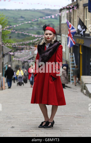 Kirsty Garwood, wearing 1940s attire, poses on the bunting draped street during the annual 1940's weekend in Haworth, West Yorks Stock Photo