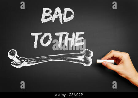 Hand writing the slogan 'Bad to the bone' on a chalkboard Stock Photo