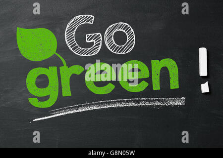 Expression 'Go green!' on blackboard Stock Photo