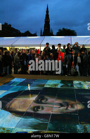 Passers-by view the giant version of Leonardo da Vinci's Mona Lisa painted by Rolf Harris and Jane Seymour and helped by 120 artists from all over Scotland in Edinburgh's Mound Precinct. Stock Photo