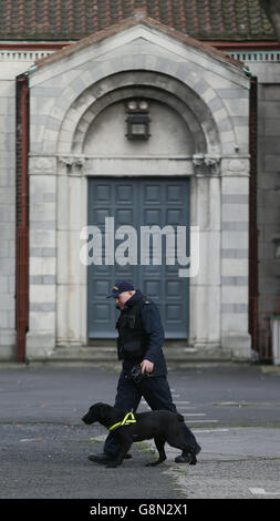 Garda sniffer dogs patrol the area around Our of Lourdes Church in Dublin before the funeral of Eddie Hutch senior who was shot dead in the north inner city last week. Stock Photo