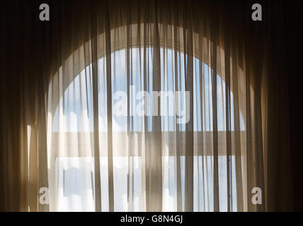 Transparent curtains on the window with arch. Stock Photo