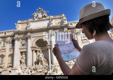 Female tourist with a map, in front of Trevi Fountain, Rome, Lazio, Italy, Europe Stock Photo