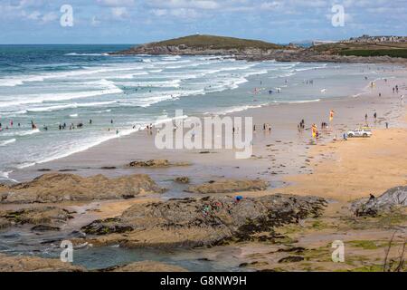A crowd of people on the beach by the sea on Fistral Beach, Newquay, Cornwall, UK