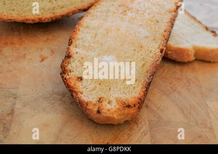 Melting butter on a slice of rustic toasted bread Stock Photo