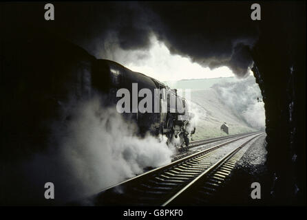 Between the tunnels on Wishing Well Bank on the climb out of Weymouth, shrouded in smoke and steam, a British Railways Standard Stock Photo