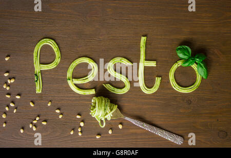 Word pesto made of cooked spaghetti with pesto souce with fork Stock Photo