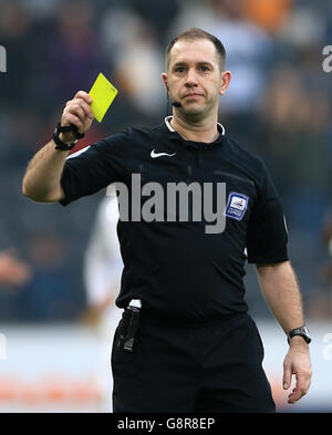 Hull City v Milton Keynes Dons - Sky Bet Championship - KC Stadium. Referee Jeremy Simpson shows the yellow card to Milton Keynes Dons' Dean Lewington Stock Photo