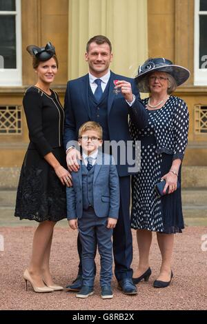 Rugby player Mark Cueto with wife Suzie, son Max and mother Anne as he holds his Member of the British Empire (MBE) medal which was awarded by the Duke of Cambridge at an investiture ceremony at Buckingham Palace, London. Stock Photo