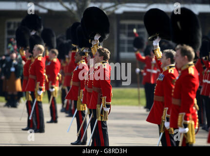 Irish Guards raise their bearskin hats in cheers for the Duke of Cambridge as he visits Cavalry Barracks in Hounslow, west London, for the regiment's St Patrick's Day Parade. Stock Photo