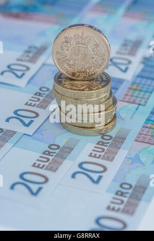 Brexit concept and Euro zone, monetary union, single market represented by some 20 Euro banknotes and old style UK Pound Sterling coins. Stock Photo