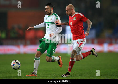 Northern Ireland's Conor McLaughlin (left) and Wales' David Cotterill battle for the ball during the International Friendly at the Cardiff City Stadium, Cardiff. Stock Photo