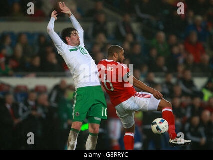 Northern Ireland's Kyle Lafferty (left) and Wales' Ashley Williams battle for the ball during the International Friendly at the Cardiff City Stadium, Cardiff. Stock Photo