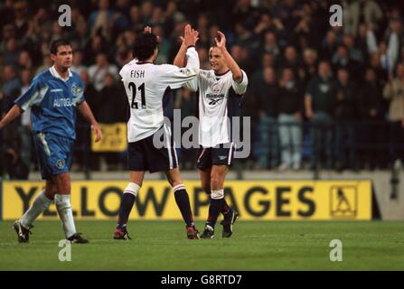 Soccer - FA Carling Premiership - Bolton Wanderers v Chelsea. Bolton Wanderers' Dean Holdsworth (right) and Mark Fish (centre) celebrate victory as Chelsea's Steve Clarke (left) walks off dejectedly Stock Photo
