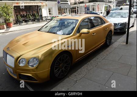 A parking ticket placed on a gold Mansory Bentley Flying from Saudi Arabia, which is parked on Lowndes Street in Knightsbridge, London. Stock Photo