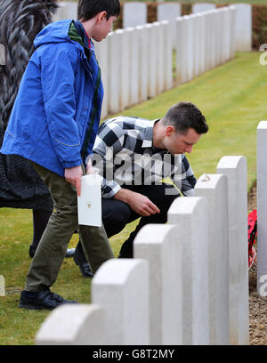 Musician Harry Judd, lays a memorial cross at the headstone during the rededication ceremony of his great great uncle The Reverend Alan Judd MC at the Fifteen Ravine British Cemetery in Villers-Plouich, France. Stock Photo