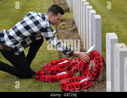 Musician Harry Judd, adjusts wreaths laid following a rededication ceremony of his great great uncle The Reverend Alan Judd MC at the Fifteen Ravine British Cemetery in Villers-Plouich, France. Stock Photo