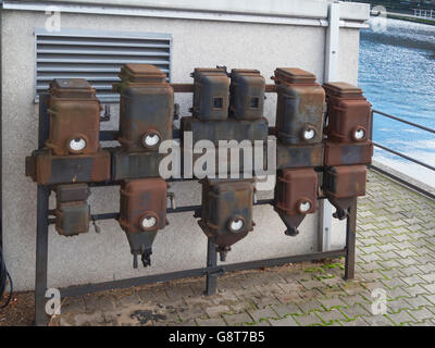 old electrical junction boxes on the white wall Stock Photo