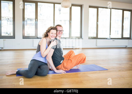 Happy couple in yoga studio smiling Stock Photo