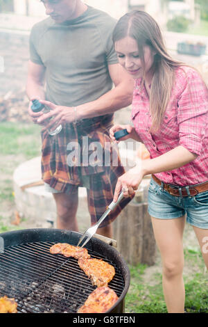 Group of friends having barbecue at campsite Stock Photo