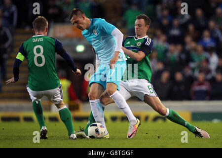 Northern Ireland's Stephen Davis (left) and Jonathan Evans (right) and Slovenia's Ilicic Josip (centre) battle for the ball during an International Friendly at Windsor Park, Belfast. Stock Photo