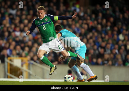 Northern Ireland's Stephen Davis (left) reacts to a challenge from Slovenia's Jokic Bojan during an International Friendly at Windsor Park, Belfast. Stock Photo