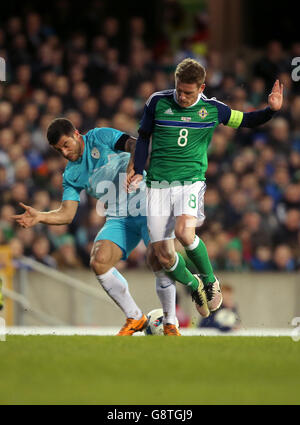 Slovenia's Jokic Bojan (left) and Northern Ireland's Stephen Davis battle for the ball during an International Friendly at Windsor Park, Belfast. PRESS ASSOCIATION Photo. Picture date: Monday March 28, 2016. See PA story SOCCER N Ireland. Photo credit should read: Niall Carson/PA Wire. Stock Photo