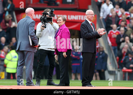 Sir Bobby Charlton (right) on the pitch with his wife Norma Ball as the South Stand is officially renamed the Sir Bobby Charlton Stand, before the Barclays Premier League match at Old Trafford, Manchester. Stock Photo