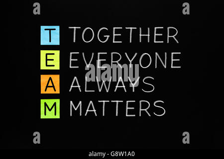 TEAM acronym Together Everyone Always Matters handwritten with white chalk on blackboard. Stock Photo