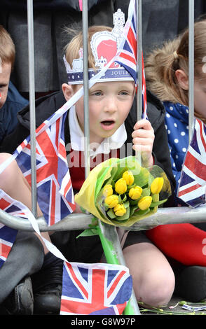 A young boy joins the crowds as they gather outside Windsor Castle in Berkshire before a walkabout by Queen Elizabeth II as she celebrates her 90th birthday. Stock Photo