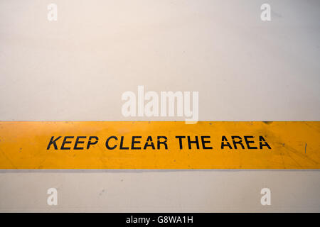 Keep clear warning sign in yellow banner on the floor, with copy space Stock Photo