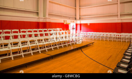 gymnasium set up with white folding chairs for an event with many people expected in Sag Harbor, NY Stock Photo