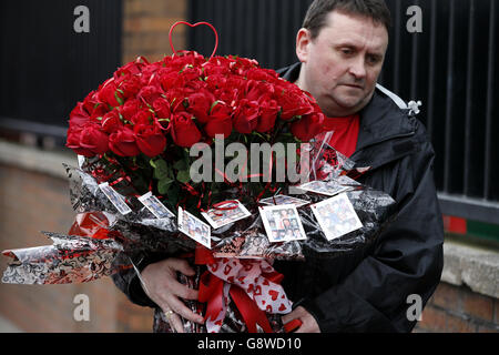 Roses are carried to be placed at the Hillsborough memorial plaque during the Hillsborough 27th Anniversary Memorial Service at Anfield, Liverpool. PRESS ASSOCIATION Photo. Picture date: Friday April 15, 2016. See PA story SOCCER Hillsborough. Photo credit should read: Peter Byrne/PA Wire. Stock Photo